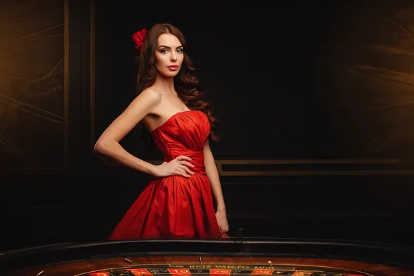A young woman relaxing with her phone while dynamic casino elements float around her, illustrating the smooth mobile experience offered by the JDLOVE app.