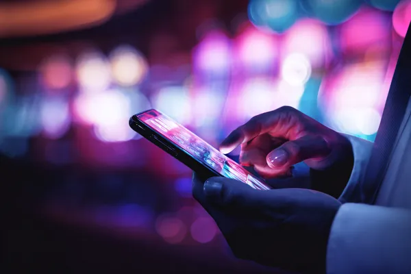 JDLOVE Slots — Thousands of thrilling machines await A woman smiling by bright slot machines showing lucky symbols, showcasing the exciting slot offerings at JDLOVE.